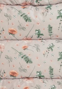 Beige quiltet stof med spredt delikat blomsterprint i blød lyserød, grønne blade og små hvide blomster.