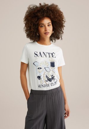 Light blue cotton t-shirt featuring a graphic design with food items and the text "SANTÉ SUNDAY CLUB" in dark colors. Round neckline, short sleeves.
