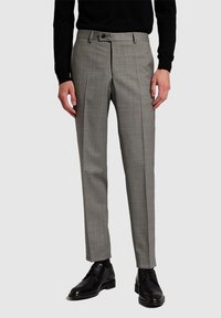 Man wearing slim-fit gray dress pants with crease, black long-sleeve top, black socks, and black leather dress shoes.