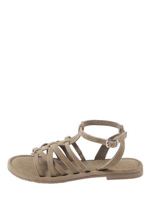 Beiger Gladiator-flacher Sandale mit mehreren Riemen und einem Knöchelriemen mit einer kleinen Metallschnalle vor weißem Hintergrund.