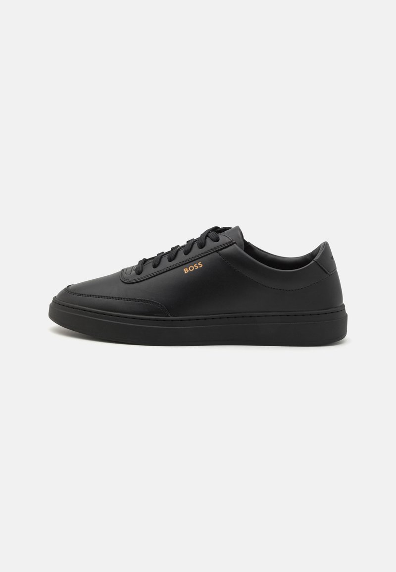 Baskets en cuir noir au design épuré, avec des lacets ton sur ton, une semelle texturée et un subtil logo "BOSS" en doré. Silhouette basse.