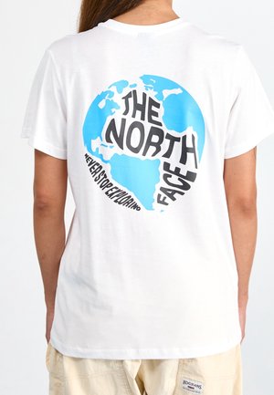 Person trägt ein weißes T-Shirt mit einer blauen Weltkugel und dem Text "THE NORTH FACE" sowie "NEVER STOP EXPLORING" auf der Rückseite.