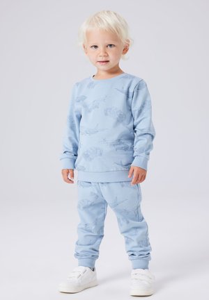 Jasnoniebieska bluza i pasujące spodnie z wzorem helikoptera i samolotu. Wykonane z miękkiej tkaniny z ściągaczami na mankietach i w pasie.