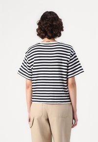 Tricou cu dungi, în nuanțe de navy și alb, cu mâneci scurte și o croială lejeră. Materialul pare moale, având un design clasic cu guler rotund.