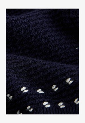 Tejido de punto en color azul marino con puntadas texturizadas y patrones en blanco. La trama parece suave, con un ligero brillo y una textura gruesa.