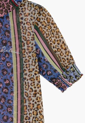 Długi rękaw z tkaniny o mieszanym wzorze panterki i kolorowych pionowych pasków, z mankietami marszczonymi i częściowym haftem kursywnym.