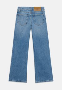 Heledad denim püksid helesinises toonis, sujuva tekstuuriga, kahe tagatasku ja tan värvi nahkpleki logo külge. 