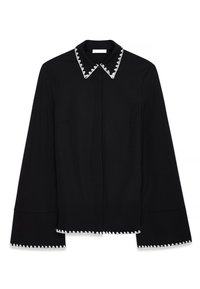Black blouse with a pointed collar featuring a white zigzag trim, long sleeves, and a straight cut. Smooth texture and simple design.