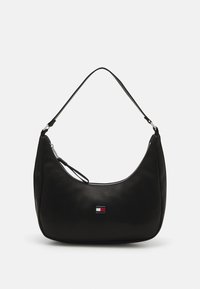 Bolso de hombro negro de nailon con forma curvada, cremallera plateada y un pequeño parche con logo en colores rojo, blanco y azul. Textura suave.