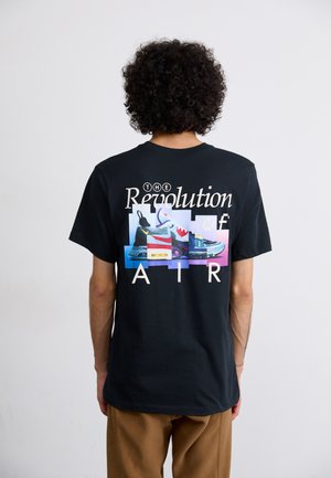 Svart bomull t-shirt med ett grafiskt tryck av färgglada sneakers och texten "THE Revolution of AIR" på ryggen.