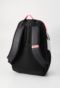 Mochila preta e rosa com alças de ombro almofadas e painel traseiro em malha, posicionada verticalmente sobre um fundo branco.