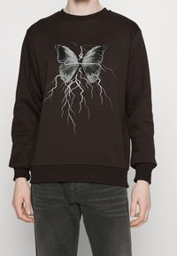 Sudadera marrón con un gran gráfico de una mariposa y rayos, con puños y dobladillo acanalados. Material de mezcla de algodón.