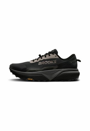 Čierna bežecká obuv Brooks s hrubou podrážkou, podrážkou Vibram, štítkom Gore-Tex a sivými akcentmi na hornej časti zmesi a šnúrkach.