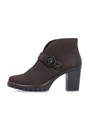 Knöchelhoher dunkelbrauner Wildlederstiefel mit klobigem Absatz, rundem Schnallenriemendetail und strukturierter Sohle.