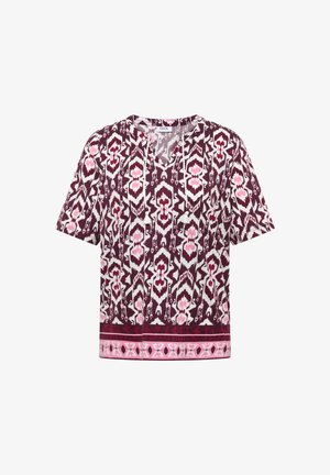 Blusa a maniche corte con fantasie geometriche bordeaux, bianche e rosa, scollo con laccetti e nappine e bordo decorativo all'orlo.
