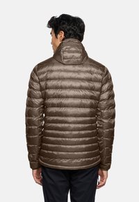 Giacca a vento marrone con design trapuntato, dotata di un alto colletto e cappuccio integrato. Tessuto liscio e lucido con righe orizzontali.