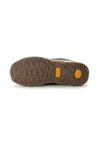 Bruine rubberen buitenzool met een gestructureerd profiel, voorzien van een geel logo en ronde details. Het bovenste gedeelte is een mix van donkere en lichte materialen.