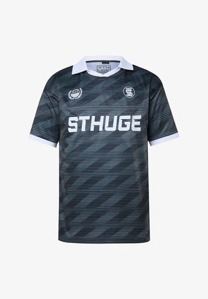 Musta ja tummanharmaa raidallinen lyhythihainen urheilupaita, jossa valkoinen kaulus, valkoiset hihansuut, "STHUGE"-logo ja kaksi pyöreää embleemiä rinnassa.