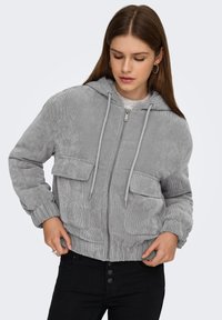 Hall kurrudriidest jakk kapuutsiga, ees lukuga ja kahe rinnataskuga. Omaduseks soonikkoes varrukasäär ja alaäär pehme tekstuuriga.