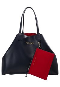 Granatowa skórzana torba tote z z�łotym logo, z czerwonym wnętrzem. Zawiera odpinaną czerwoną kieszonkę na zamek błyskawiczny. Gładka tekstura, zaokrąglony kształt.