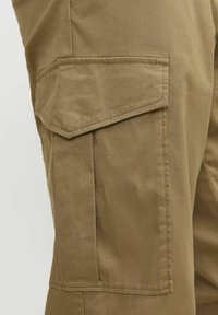 Beige cargobroek met een zijzak, gemaakt van katoen, met een gladde textuur en versterkte stiksels.