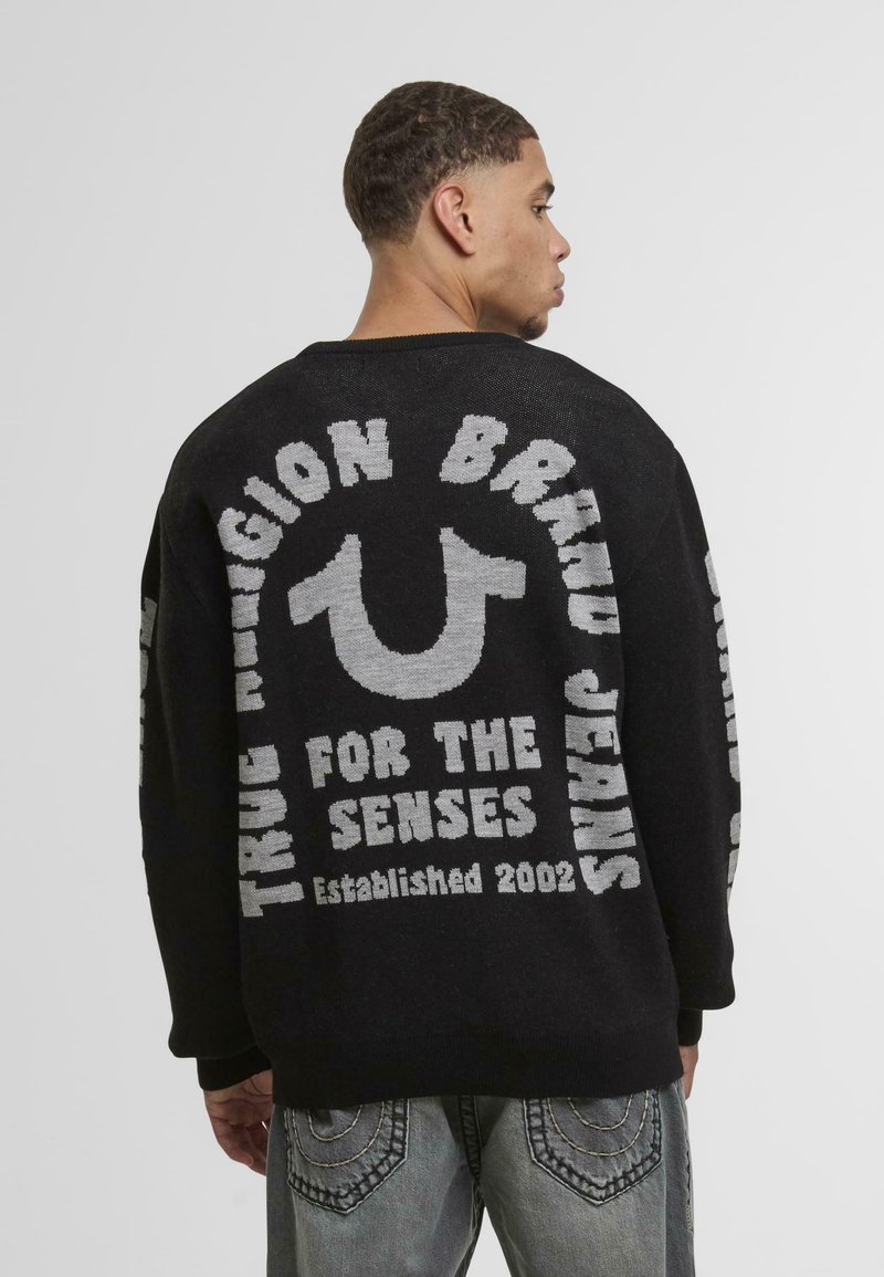 Black knitted sweater featuring gray text and a logo design on the back, with a relaxed fit and long sleeves.