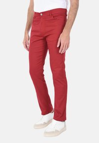 Pantaloni slim-fit rossi realizzati in un mix di cotone, caratterizzati da una texture liscia, design classico a cinque tasche e chiusura con bottone metallico in vita.