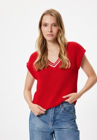 Top de punto rojo de manga corta con escote en V y detalles en rayas blancas. Tejido texturizado; corte holgado con hombros caídos y un diseño casual.