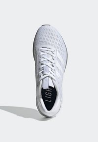 Zapatilla atlética blanca con parte superior de malla transpirable, textura acanalada, cordones planos y plantilla acolchada que presenta la palabra "LIGHT" en negro.