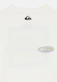 Biała koszulka T-shirt z miękkiej bawełny, z okrągłym dekoltem. Na przodzie znajduje się niebieskie i pomarańczowe logo Quiksilver.