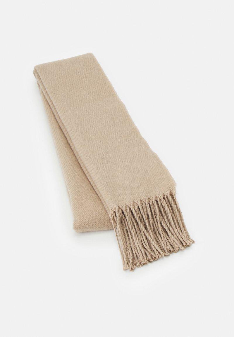 Beige skjerf laget av mykt materiale, med en jevn tekstur og frynser på den ene enden. Sammenbrettet pent for utstilling.