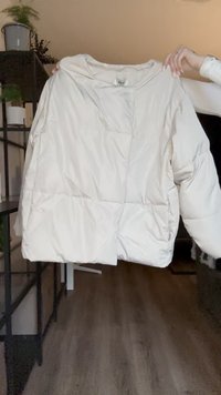 Kerge, off-white värvi пуховik, millel on kastja kuju, kildkonstruktsioon ja ümar kaelus. Omab elastseid mansette ja lõdva istuvust.