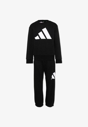 Completo con felpa nera a maniche lunghe e pantaloni, con grande logo Adidas bianco sul petto e logo più piccolo sulla coscia sinistra.