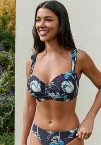 Deze bloemenbikini set heeft een donkerblauwe achtergrond met witte en teal bloemen. De top heeft een geraffineerd midden en brede schouderbanden.