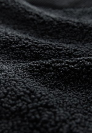 Črn, teksturiran material z mehko, volneno površino, ki vsebuje dvignjene, zanke niti. Material ima bogato, temno barvo.