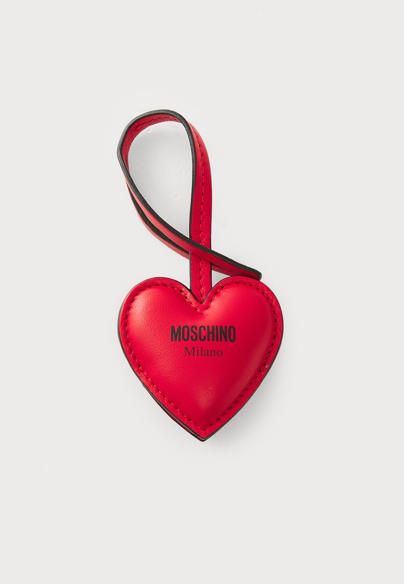 Punane nahast südametorn koos musta aktsentrihmaga. Omab musta trükitud kirja "MOSCHINO" ja "Milano". Sile tekstuur.