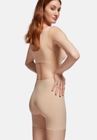 Light beige seamless bra and control shorts set, featuring a smooth texture, wide straps, and a high-rise fit with no visible seams.