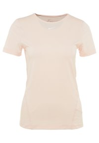 Camiseta deportiva de manga corta en rosa claro, fabricada con tejido transpirable y con un escote redondo. Presenta una sutil textura y el logo de Nike en el pecho.