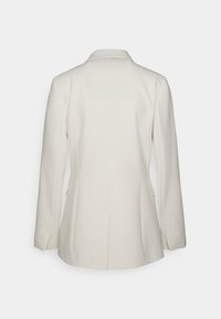 Crème-kleurige blazer met een gestructureerd ontwerp, met notch-revers, lange mouwen en zijzakken. Dikke stof met een getailleerde pasvorm.