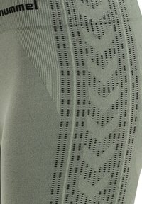 Zielone legginsy sportowe z teksturowanym żebrowaniem i czarnym logo. Posiadają na boku naprzemienne poziome i strzałkowe detale.