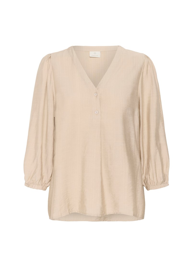 Blouse beige à manches longues avec col en V, deux boutons à l'avant, manches bouffantes froncées et poignets élastiques.