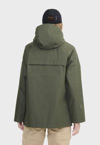 Veste à capuche verte avec une coupe décontractée, dotée d'un empiècement au dos et d'un logo discret sur la manche, fabriquée dans un matériau durable.