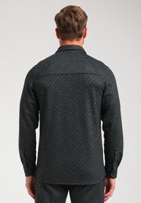 Langere mouwen shirt in donkergrijs met een visgraatmotief, knoopmanchetten en een kraag. De stof heeft een gestructureerde uitstraling.