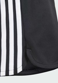 Pantalones cortos deportivos negros con tres rayas verticales blancas en el lado, hechos de una tela suave y con un dobladillo curvado.