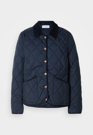 Veste matelassée bleu marine avec col noir, boutons-pression dorés, deux poches frontales et motif de piqûre en losanges.