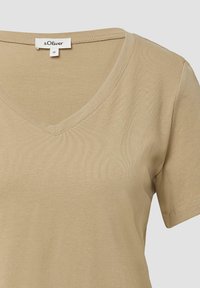 Beige V-Ausschnitt T-Shirt mit kurzen Ärmeln, aus glattem Baumwollstoff; Etikett sichtbar am Hals, verfügt über ein einfaches und minimalistisches Design.