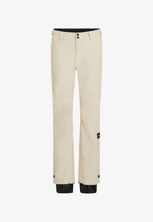 Pantalones impermeables color beige con dos cierres de botón, una cremallera y un dobladillo negro ajustable. Cuenta con una etiqueta de logo en la pierna izquierda.
