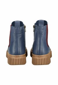 Boty s modrou koženou svrškem a červenými bočními akcenty, s texturovanou hnědou gumovou podrážkou a zipovým uzávěrem na zadní straně.