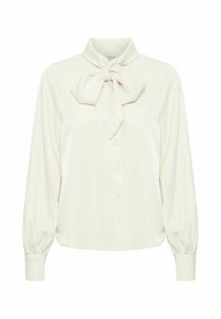 Blouse en ivoire avec un col à nœud noué, de longues manches bouffantes et une fermeture à boutons sur le devant. Tissu doux et lisse avec un léger éclat.