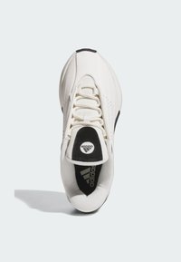 Vita atletiska sneakers med ovandel i mesh, svarta accenter och en rund logo på plösen. Har snörningssystem och rundad tådesign.